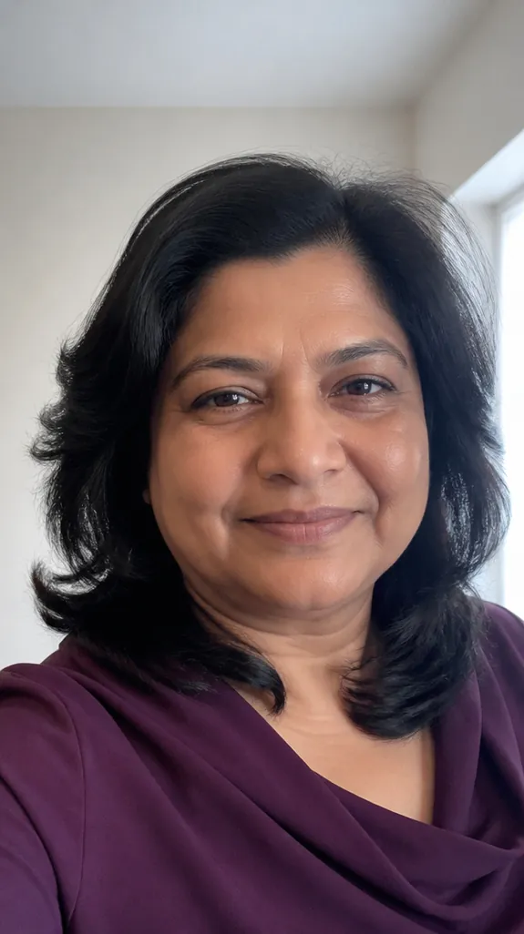 woman in her fifties with a round face and shoulder-length feathered layers