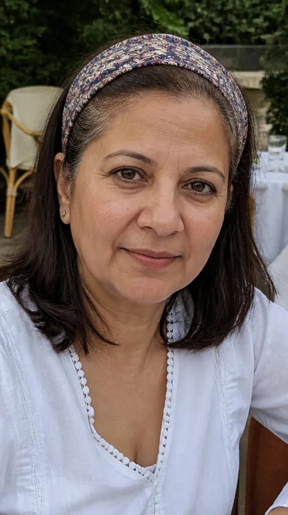 woman in her fifties wearing a wide patterned headband over gray roots
