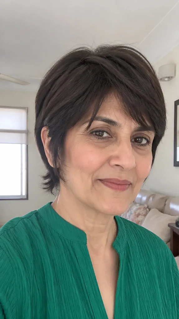 woman in her fifties with a razor-cut dark bixie with feathered ends